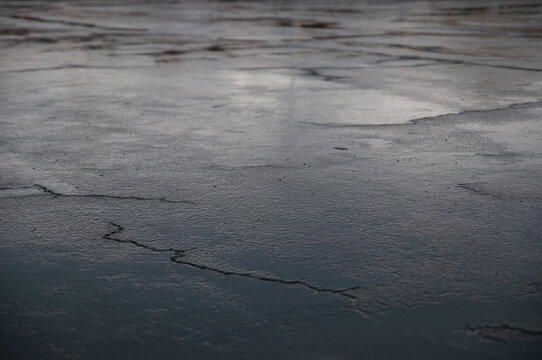 Sky reflection on wet concrete after rain with cracks