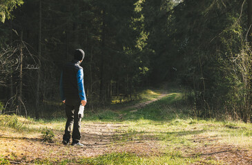 Man in a fleece and vest takes off his mask after quarantine and enjoys walking in forest alone....