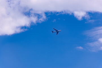 Fototapeta na wymiar Commercial plane flight on blue sky
