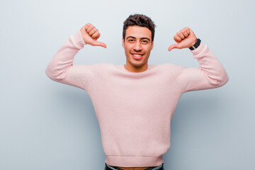 young arabian man feeling proud, arrogant and confident, looking satisfied and successful, pointing...
