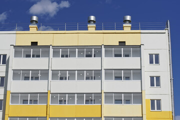 Windows and balconies of the upper floors of a new, not yet populated, multi-storey building. Housewarming, sale of new apartments, studios and apartments