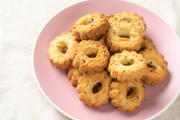 Shortbread in a pink ceramic plate on a light table. A plate of cookies on the table close-up. Top view with space for text