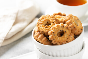 Shortbread in a white ceramic plate on a light table. A plate of cookies on the gray kitchen table. Cookies close up