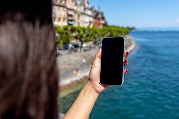 Frau mit Handy am See
