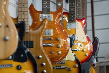 Plakat Selective focus of different electric guitars in a row hanging in a modern musical shop