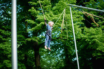 The girl is jumping on a bungee trampoline. A child with insurance and stretchable rubber bands...