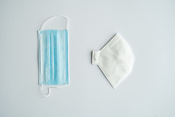 Respirator ffp and medical masks lie on a gray background. Anti-virus protection kit against covid-19. Coronavirus pandemic 2019.