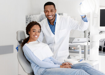 Dentist and patient posing together at modern dental clinic