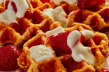 Still life of waffles with strawberry and yogurt on them,shot from above.