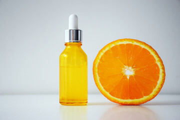 Vitamin C serum in cosmetic bottle and half of orange on white background. Organic SPA cosmetics with herbal ingredients. Citrus essential oil, cosmetics aromatherapy. Flat lay.