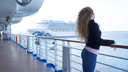 Girl circus gymnast performs a show on the air hoop. flexible acrobat spins on a ring in the air on a black background. slender young girl performs split in the air