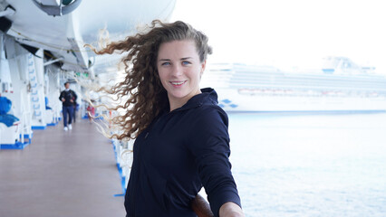 Girl circus gymnast performs a show on the air hoop. flexible acrobat spins on a ring in the air on a black background. slender young girl performs split in the air