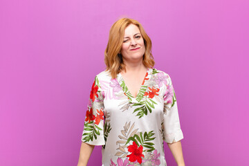 middle age woman looking happy and friendly, smiling and winking an eye at you with a positive...