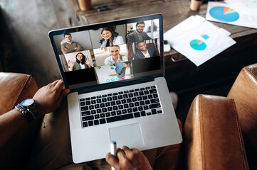 Video call. Online business meeting. Business colleagues communicate by a video conference using a laptop, discussing about business affairs. On a laptop screen, participants of a video conference - obrazy, fototapety, plakaty