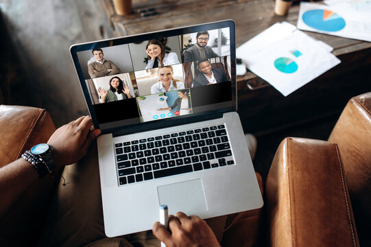 Video call. Online business meeting. Business colleagues communicate by a video conference using a laptop, discussing about business affairs. On a laptop screen, participants of a video conference