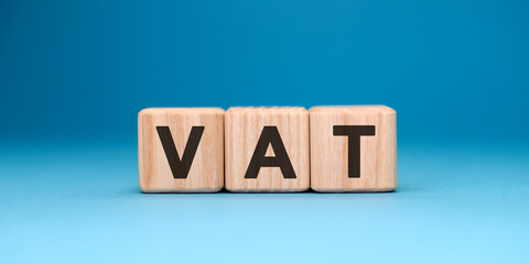 VAT - text concept on wooden cubes with gradient blue background