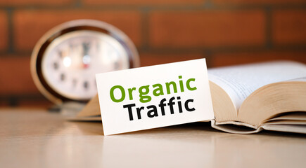 Organic seo traffic - concept text on a white background with a clock and an open book