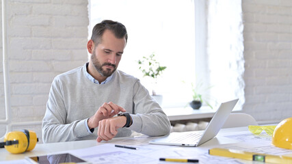 Focused Young Architect using Smartwatch at Work