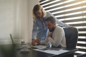 Young businessman signing contract with his secretary at the office - Man and woman manager checking documents at work - Two people analyzing documents giving advice cooperation concept