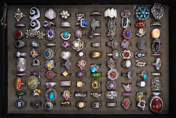 Assorted colorful vintage rings on a flea market stall sale in Italy, various designs and materials...