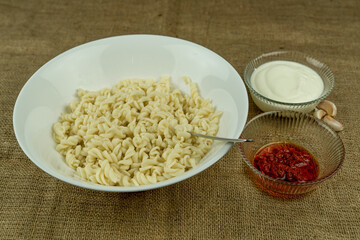 Turkish stile spiral pasta is served with yogurt and tomato sauce