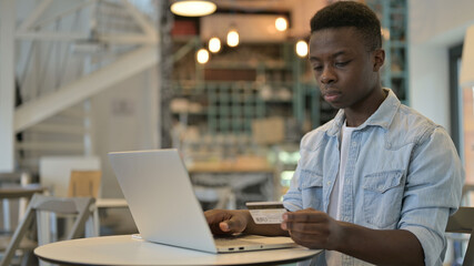 Fototapeta premium African Man Doing Online Payment with Credit Card