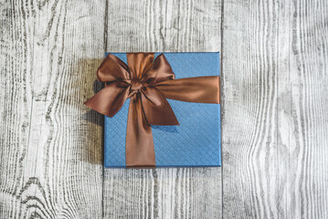 A blue gift on the wooden background.