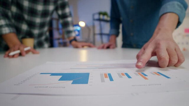 Millennial Asia businessmen meeting brainstorming ideas about new paperwork project colleagues working together planning success strategy enjoy teamwork in small modern night home office.