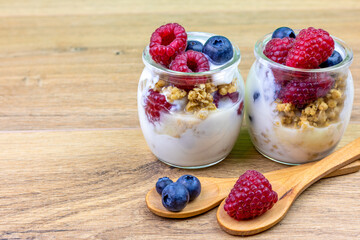 jars of yogurt with muesli, blueberries and raspberries