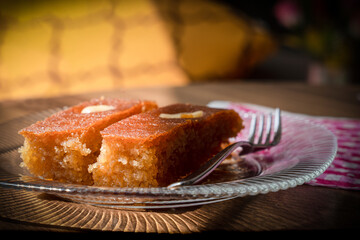 Turkish Dessert sambali, sambaba or sam tatlisi served in a plate with fork and knife on brown...