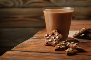 Delicious ginger cookies, with a glass of hot cocoa, on the edge of a wooden table.

Язык ключевых слов: English