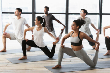Yoga practice. Group of interracial young people doing Mermaid pose