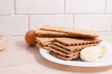 rye and wheat bread crisps on the table, proper and healthy nutrition concept, dietetic products for breakfast, ingredients for a sandwich, egg and hummus
