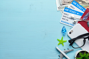 Vacation and holidays concept - airplane with tickets, money, passport on a blue wooden background.