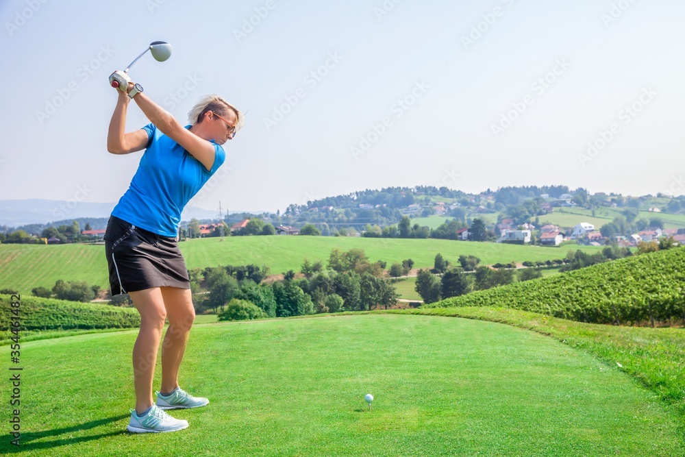 Sticker woman golfer hitting a ball on the green, with vineyard in the background at zlati gric in slovenia