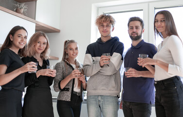 Group of happy friends celebrating and toasting with glasses