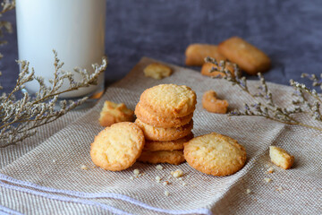 Fresh baked butter cookies with milk. Homemade oven cookies on a dark moody background.