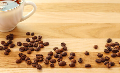 Banner: coffee beans are scattered on a wooden background next to a Cup of tea-the concept of a good pleasant meeting, a place for the inscription