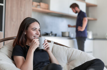Beautiful young woman drinking coffee in kitchen