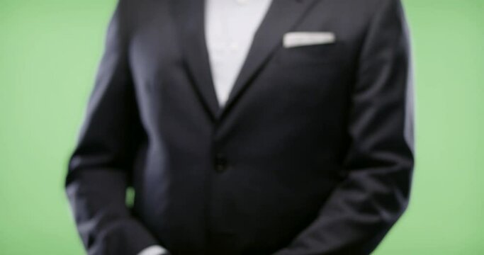Businessman wink &amp; gun on green screen. Shot in slow-motion in 4k. Businessman gives client the wink & gun after closing deal.