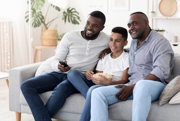 Cheerful african grandpa, father and son relaxing together in living room