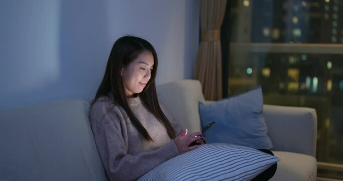 Woman work on cellphone at home in evening