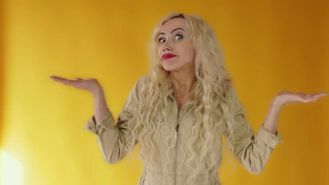 What's wrong. The embarrassed and intense woman shrugged, spread her arms. Shocked bewildered woman blonde colleague shrugging shoulders complete disbelief asks a question doubts puzzled situation