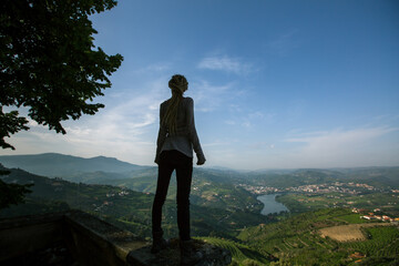 Obraz premium Woman traveller on the hill looks at on of the Douro Valley, Porto, Portugal.