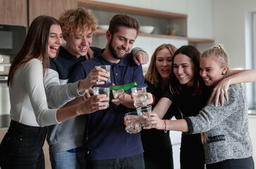 Cheerful young friends opening bottle of champagne