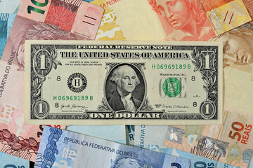 Fototapeta na wymiar Nota de 1 dólar junto com reais brasileiros de diversos valores