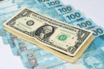 Notas de 1 dólar junto com notas de cem reais brasileiros 