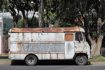 Fototapeta na wymiar Old rusty bus on the side of the street.