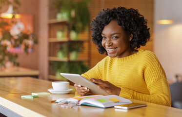 Cheerful african girl using social media on digital tablet