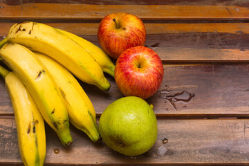 Colorful fresh summer fruits on brown wooden background, healthy organic food on table, detox vitamin nutrition for health care, top close up view, copy space